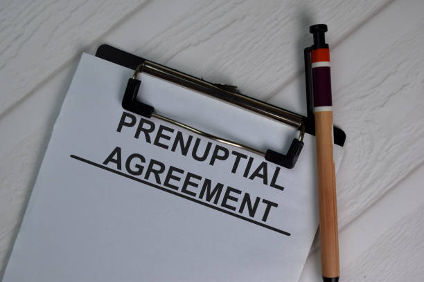 istock Prenuptial Agreement write on paperwork isolated on office desk. 1279585996