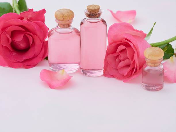 istock Aromatherapy oil bottles with roses on pink background 1279591593