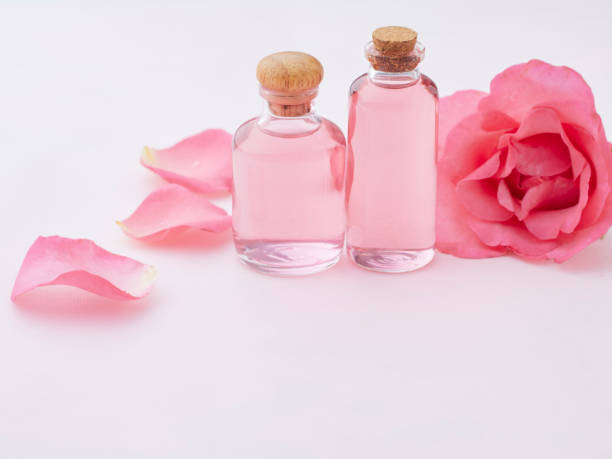 istock Aromatherapy oil bottles with rose on pink background 1279591629