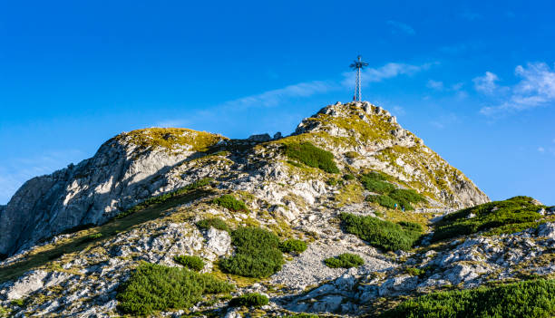 croix au sommet de giewont. une destination touristique populaire pendant les vacances d’été. vue sur une belle journée ensoleillée d’été. - poland mountain tatra mountains giewont photos et images de collection