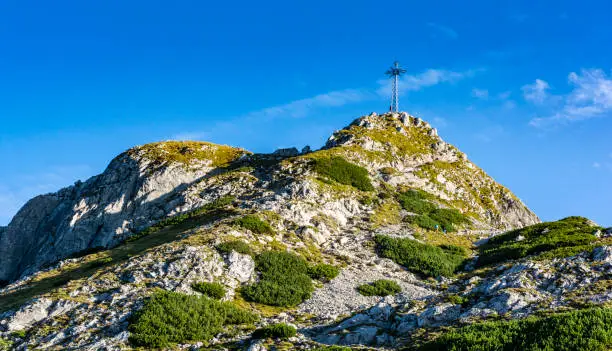 Photo of Cross at the top of Giewont. A popular tourist destination during the summer holidays. View on a beautiful sunny summer day.