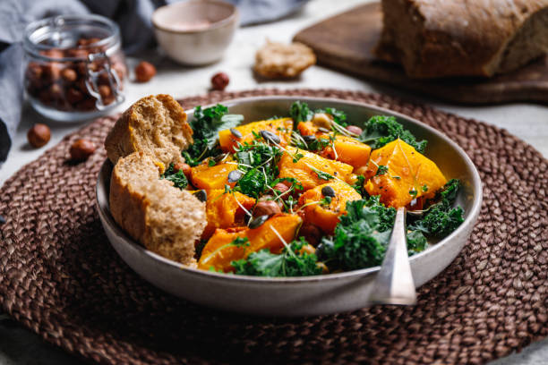 season salad with grilled pumpkin, kale, chickpea, pepitas and nuts. autumn vegetarian healthy recipe. - butternut squash roasted squash cooked imagens e fotografias de stock