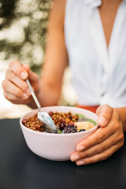 istock Woman eating smoothie bowl 1279607264