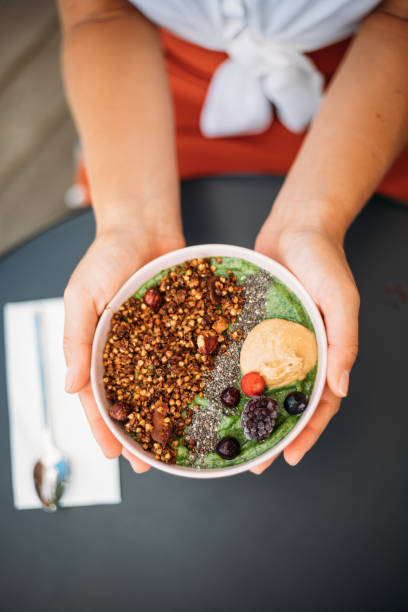 istock Woman eating smoothie bowl 1279607463