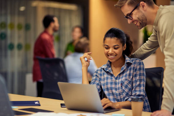 istock Young cheerful caucasian man helping female coworker with computer work, two young multiracial colleagues using laptop and discussing project 1279609768