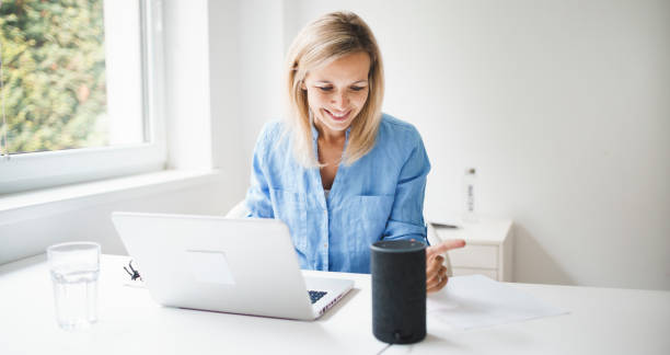 istock beautiful young woman is talking to a smart speaker 1279614453