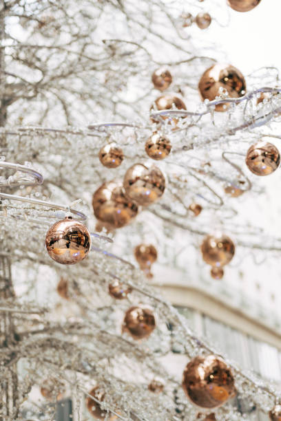 istock Gold glossy Christmas balls on a white glass Christmas tree. 1279615577