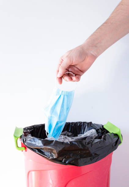 istock Hand throws used medical mask into the trash 1279617452