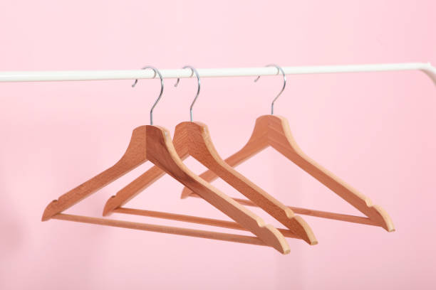 istock empty clothes hangers on a wardrobe rack on a colored background. 1279617614