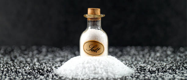 old vintage Salt Miniature glass and heap of Crystals of sodium carbonate on a dark table. concept excessive salt intake. Background for advertising. Salted food. sodium intake stock pictures, royalty-free photos & images