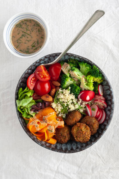 istock Couscous salad with fresh vegetables and a dressing on the side 1279618710
