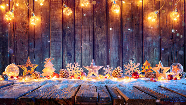 weihnachtsschmuck mit lichterketten auf rustikalen holztisch - christmas stock-fotos und bilder