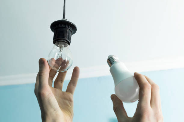 istock Incandescent lamp is changed to LED light by the hands. Energy saving. 1279622295