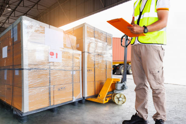 istock Cargo freight truck, Shipment boxes, Delivery service. Warehouse worker holding clipboard his control loading cargo pallet into shipping container. 1279624440