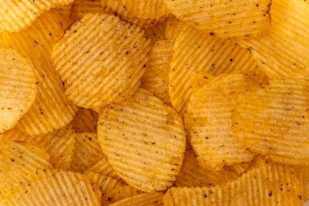 istock top view corrugated golden chips background, grooved pattern and texture of fast food for copy space 1279624461