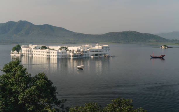 Elevated view of lake Pichola and lake Palace. Udaipur, India. Elevated view of Lake Pichola and Lake Palace hotel with Aravalli hills in background on a bright morning in Udaipur, Rajasthan, India. lake palace stock pictures, royalty-free photos & images