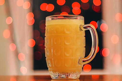 Mug of kvass is a traditional ukrainian sour drink, which is made from dry rye bread, sometimes with the addition of odorous herbs with bokeh light background