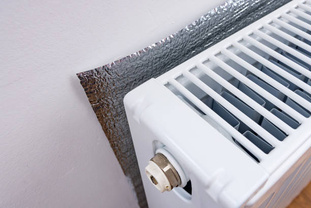 istock Energy-efficient foil thermal insulation on the wall behind the heating radiator. 1279628710