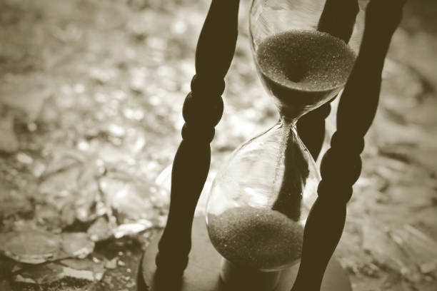istock Sand clock on broken glass pieces in blur. 1279630929