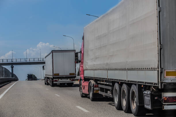 istock Trucks deliver cargo in opposite directions on a suburban highway 1279631097
