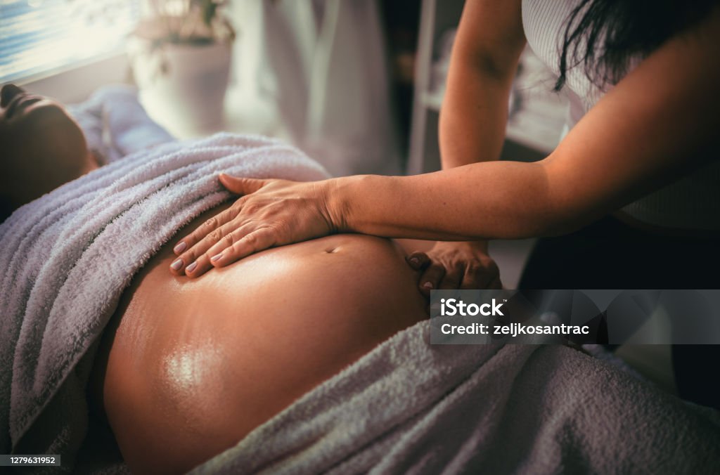 Pregnant woman having massage in spa relax Massaging Stock Photo