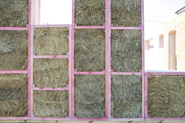 Photo of Construction of a house from an environmentally friendly material of plant origin. Frame made of wood, blocks of straw.