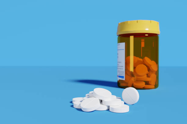istock White pills next of pill bottle isolated on blue background. Selective focus. 3d illustration. 1279633301