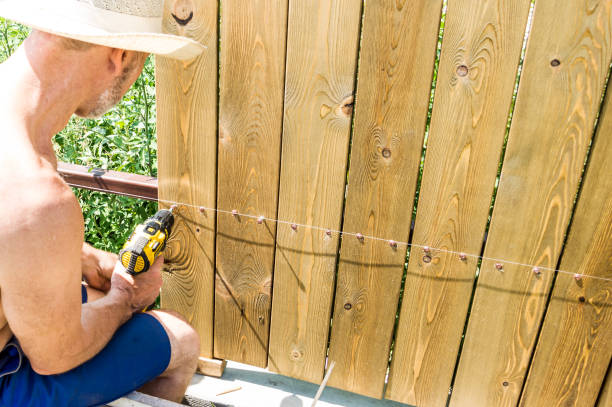istock A man builds a wooden fence. 1279633777
