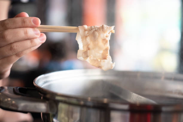 baguettes de fixation à la main avec bacon mûr dans le pot chaud de shabu shabu et de sukiyaki - buffet thai cuisine asian ethnicity food photos et images de collection