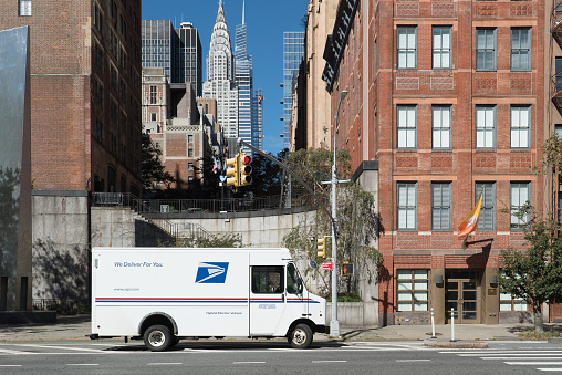 Manhattan, New York. October 08, 2020. USPS delivery truck with view of Chrysler Building, parked on first avenue in Midtown.
