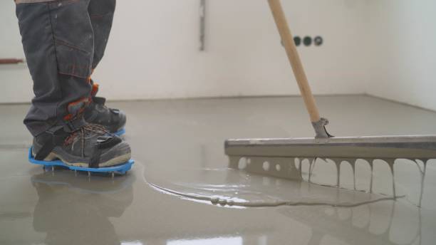 Interior of apartment under construction. Mirror smooth surface of the floor. Floor covering with self leveling cement mortar. Roller application stock photo