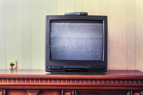 istock vintage tv screen with glitch static image stands on wooden table in room 1279638512