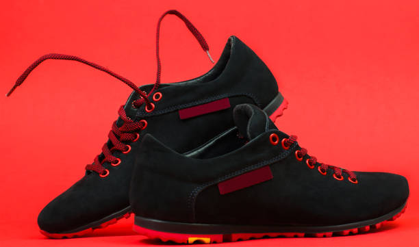 istock A pair of black sneakers on a red background 1279639878