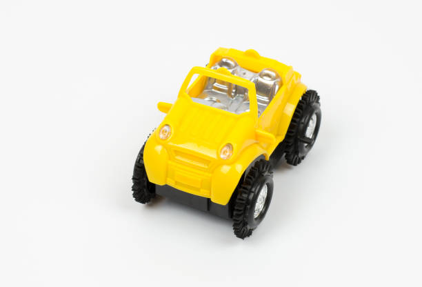 A yellow toy car with large black wheels on a white background.
