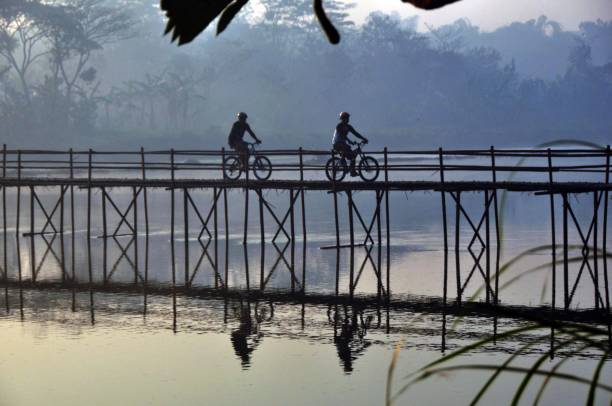 People cross the bamboo bridge in the morning People cross the bamboo bridge in the morning. Bamboo bridge in Bantul yogyakarta, 24 Juli 2020. bamboo bridge stock pictures, royalty-free photos & images
