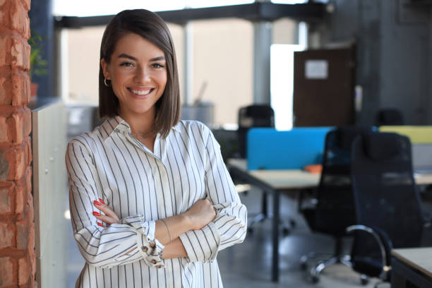 istock Attractive business woman looking at camera while standing in the office. 1279644985