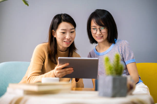 istock Two female friends looking at a digital tablet 1279645976