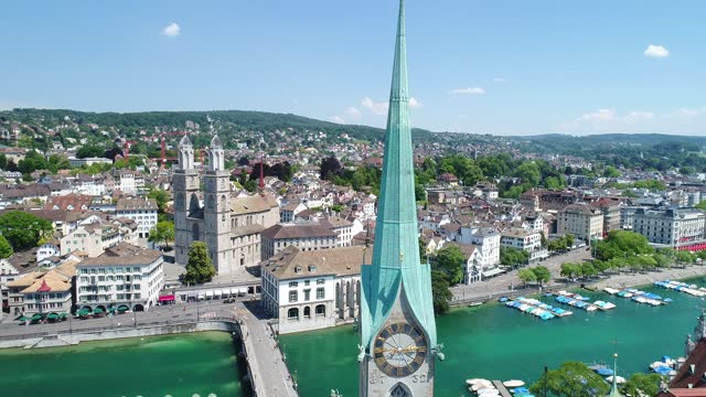 Flying over Zurich, Switzerland and the River Limmat on this beautiful summer day. You can see the famous churches, tourist boats and the city life.