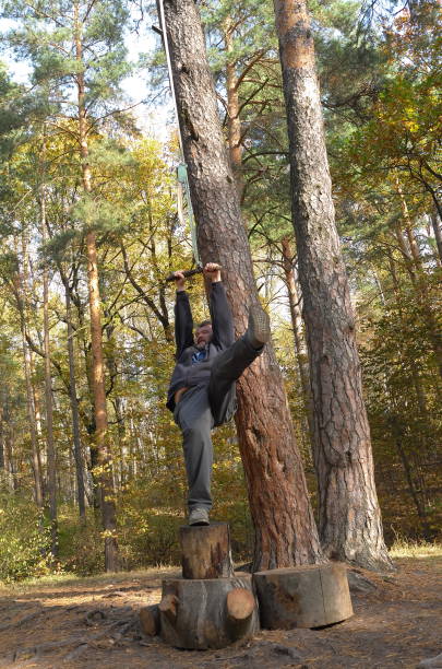 istock Man is swinging on the rope swing in autumn forest 1279648869