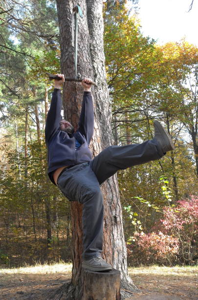 istock Man is swinging on the rope swing in autumn forest 1279648907