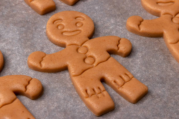 istock raw dough with gingerbread men on baking paper background ready for the oven, traditional homemade biscuit for Christmas time 1279649984