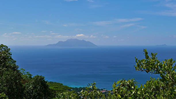 Panoramic view from Dans Gallas hiking trail in the north of Mahe, Seychelles over the northern coastline with the silhouettes of Silhouette Island and Ile du Nord. stock photo