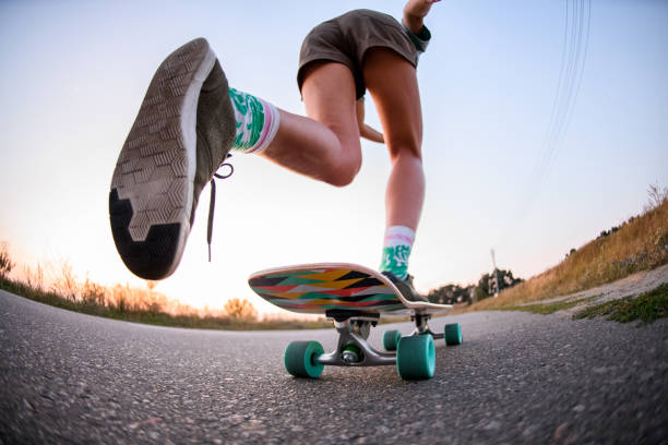 visão de baixo ângulo de menina que está andando de skate no asfalto. - skateboard park extreme sports recreational pursuit skateboarding - fotografias e filmes do acervo