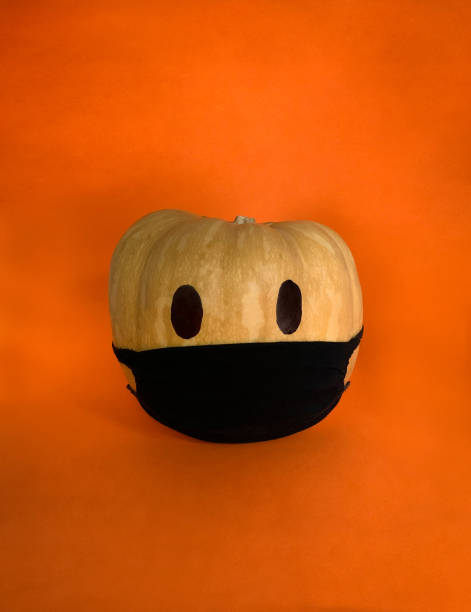 istock Coronavirus Halloween pumpkin in a protective mask on a orange background 1279651655