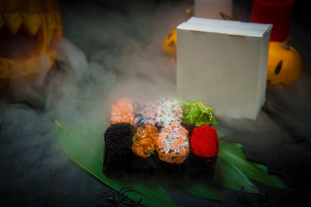 set of gunkan sushi near halloween decoration. pumpkin jack o lantern exhaling smoke - 7678 imagens e fotografias de stock