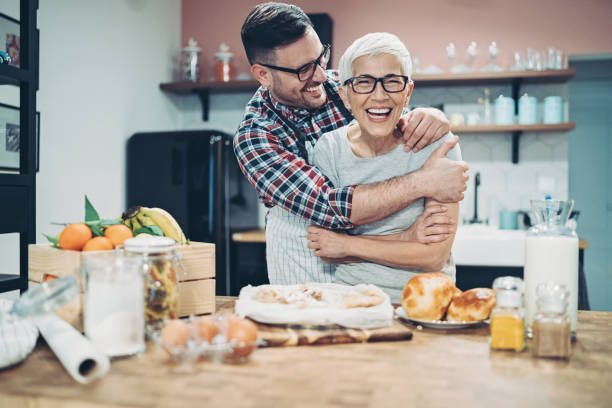 母と大人の息子は台所で一緒に幸せ - mother son family cooking ストックフォトと画像