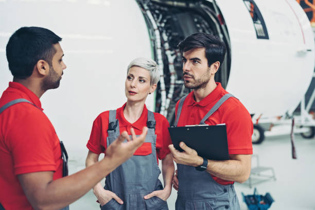 istock Group of airplane technicians talking in the hangar 1279655918