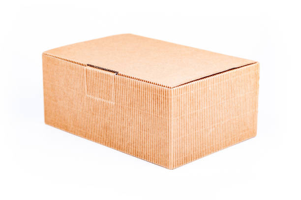 istock Simple single small brown corrugated cardboard delivery carton box with a lid closed isolated on white background, object cut out, closeup. Shipping, transportation and packaging, storage concept 1279657151