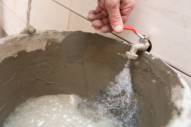 istock During construction work, a manual worker pours tap water into a black bucket. 1279663462