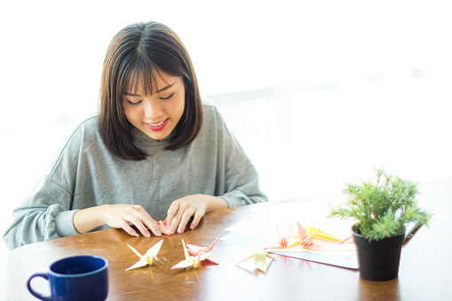 Young woman folding oregami